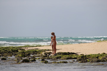 Woman and child walk the beach.