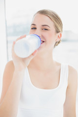 Happy sporty woman drinking water from her flask