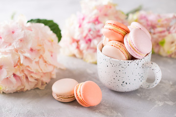 Spring mood still life with macaroons in cup and flowers