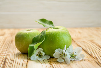 Three apples with flowers on a wooden brown background