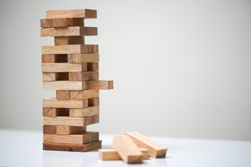 Planning, risk and strategy in business, businessman and engineer gambling placing wooden block on a tower.