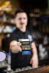 Male barista making payment with credit card