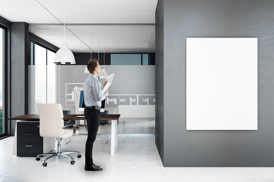 Businessman in modern office with poster