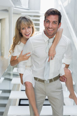 Smiling young man carrying woman