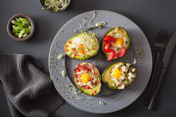 eggs baked in avocado with bacon, cheese, tomato and alfalfa sprouts