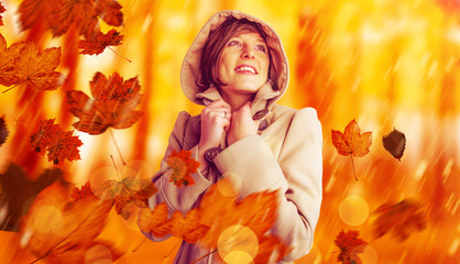 Smiling beautiful woman in winter coat looking up against view of a forest in the mist