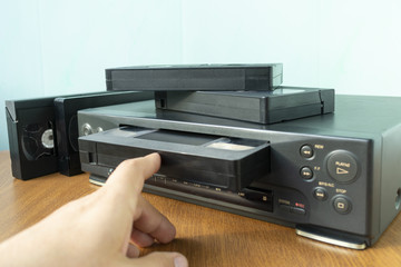 insert a videotape into a tape recorder