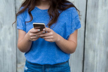 Woman in blue top using mobile phone