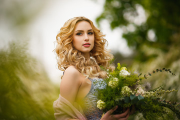 Naklejka premium Beautiful boudoir Bride in bathrobe dress on landscape background forest