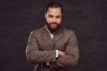 Confident African-American businessman in a brown classic jacket with crossing arms.