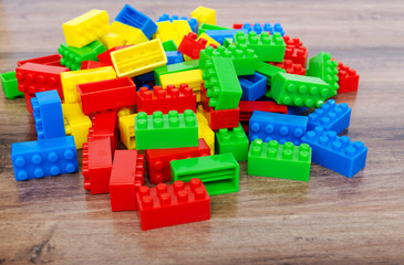 Colorful toy building blocks on wood background.
