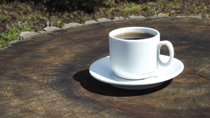 Cup of aromatic coffee on wooden background.