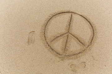 Fototapeta na wymiar Peace sign on the sand