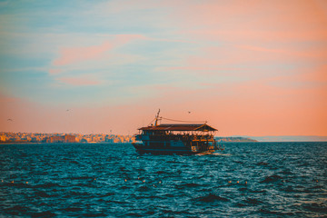 Obraz premium Tourist ferry or sightseeing boat crossing a bay