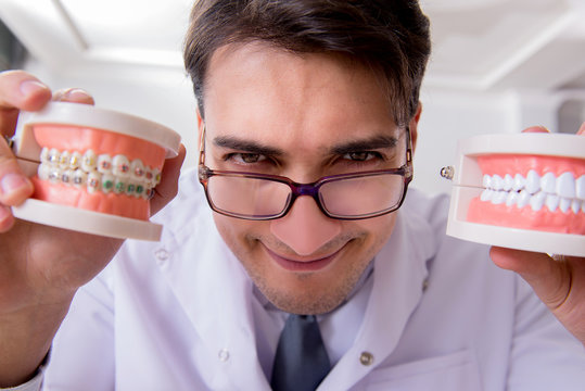 Funny dentist with teeth model in hospital