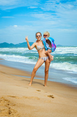 Caucasian Mom and daughter in sunglasses in the summer on the beach
