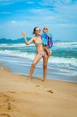 Caucasian Mom and daughter in sunglasses in the summer on the beach