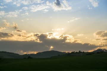 Obraz na płótnie Canvas Sunset on meadow with hills and tree. Slovakia