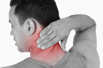 Fototapeta premium Young male massaging his back against a white background