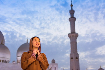 Woman praying in the mosque at dusk