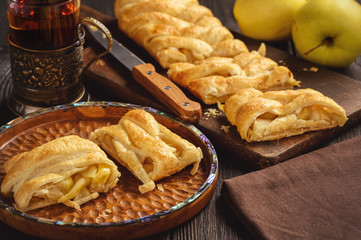 Apple puff pastry braid, on dark background.