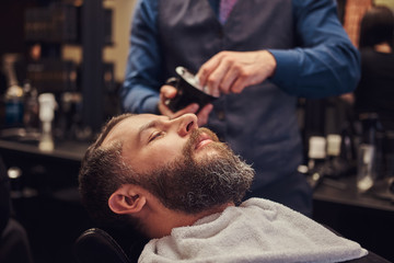 A master hairdresser prepares the face for shaving, deals foam.