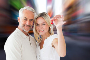 Happy couple showing their new house key against blurry new york street