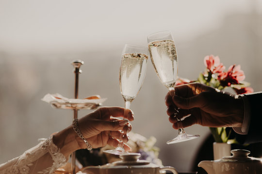 Unrecognizable female and male have special occasion in their life, hold glasses with champagne, clink glasses, have festive event. Celebration concept