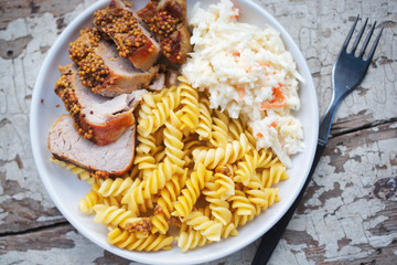 Pork loins in mustard sauce with pasta and cabbage and carrot salad