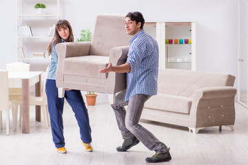 Fototapeta na wymiar Man moving armchair in the living room