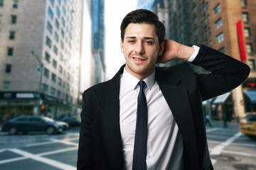 Businessman in tie and suit poses on the street