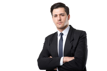 Young serious businessman in tie and suit poses