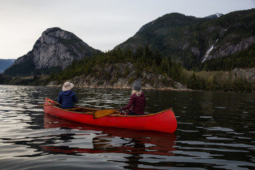 Adventurous people on a canoe are enjoying the beautiful Canadian Mountain Landscape. Taken in...