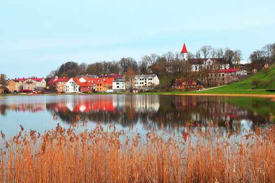 Beautiful old town houses with lake reflection in spring morning in Talsi Latvia.