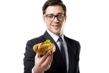 Young businessman eats burger, white background