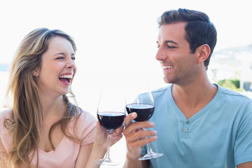 Cheerful young couple toasting wine glasses