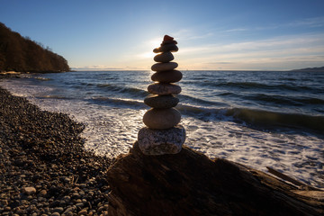 Fototapeta na wymiar Stack of Rocks piled up by the ocean during a sunny sunset. Taken in Wreck Beach, Vancouver, British Columbia, Canada.
