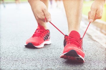 Running shoes. Barefoot running shoes closeup. male athlete tying laces for jogging on road. Runner ties getting ready for training. Sport lifestyle.