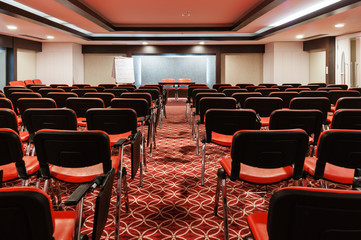 rows of red chairs in empty conference hall