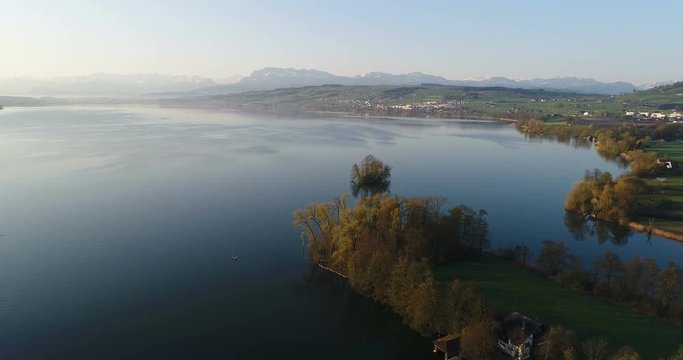Aerial view on a spring morning from the lake shore of lake Sempach near the city of Sursee with Mount Pilatus in background in central Switzerland