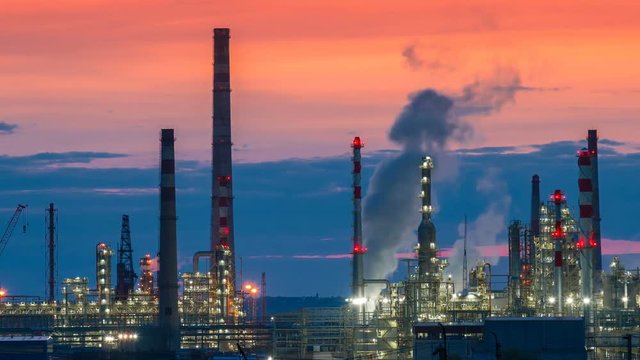 Oil and gas refinery factory and smoke stack at twilight. Timelapse 4K