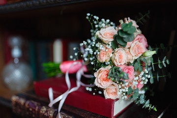 Stylish bouquet of flowers lies on the red book in the library Wedding bouquet of fresh flowers, close-up, loft style.