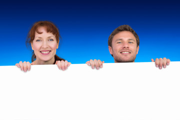 Couple looking at the camera against blue sky over clouds