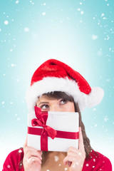 Portrait of a festive young woman holding a gift against blue vignette