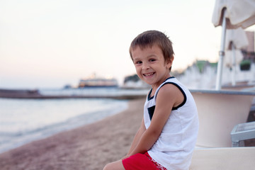Fototapeta na wymiar Portrait of cute child, boy, contemplating the beach on sunset