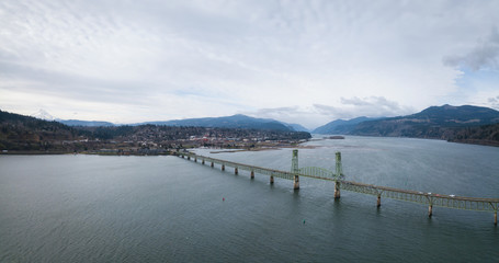 Naklejka premium Aerial panorama of a bridge going over Columbian River between Oregon and Washington during a winter day.