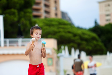 Sweet little child, boy, eating ice cream on the beach
