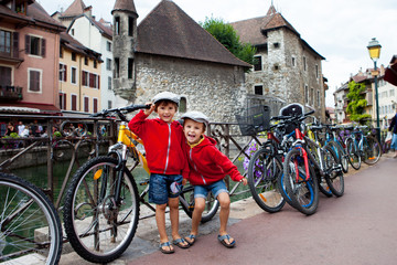 Fototapeta na wymiar Portrait of two boys, brothers, in the town of Annecy, next to a channe