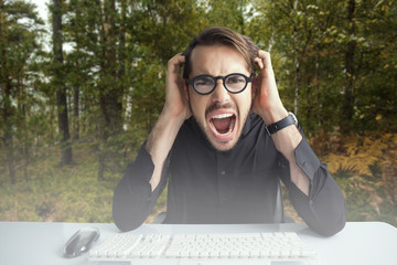 Businessman yelling with his hands on face  against scenic view of walkway along lush forest