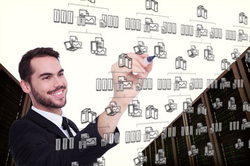 Smiling businessman writing with black marker against cloud computing doodle